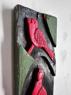 Carved wooden bird panel in red green and black