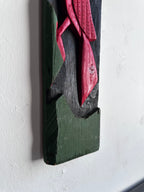 Carved wooden bird panel in red green and black