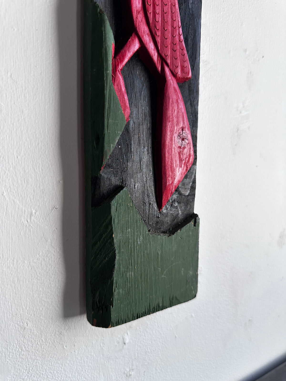 Carved wooden bird panel in red green and black